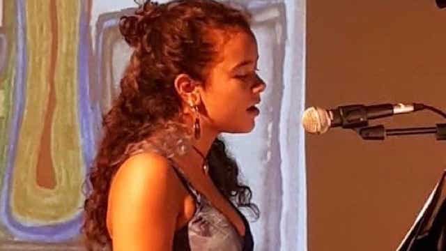 alumna tocando piano y cantando