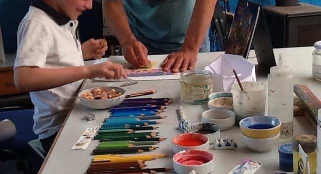 niño en clase y lápices de color